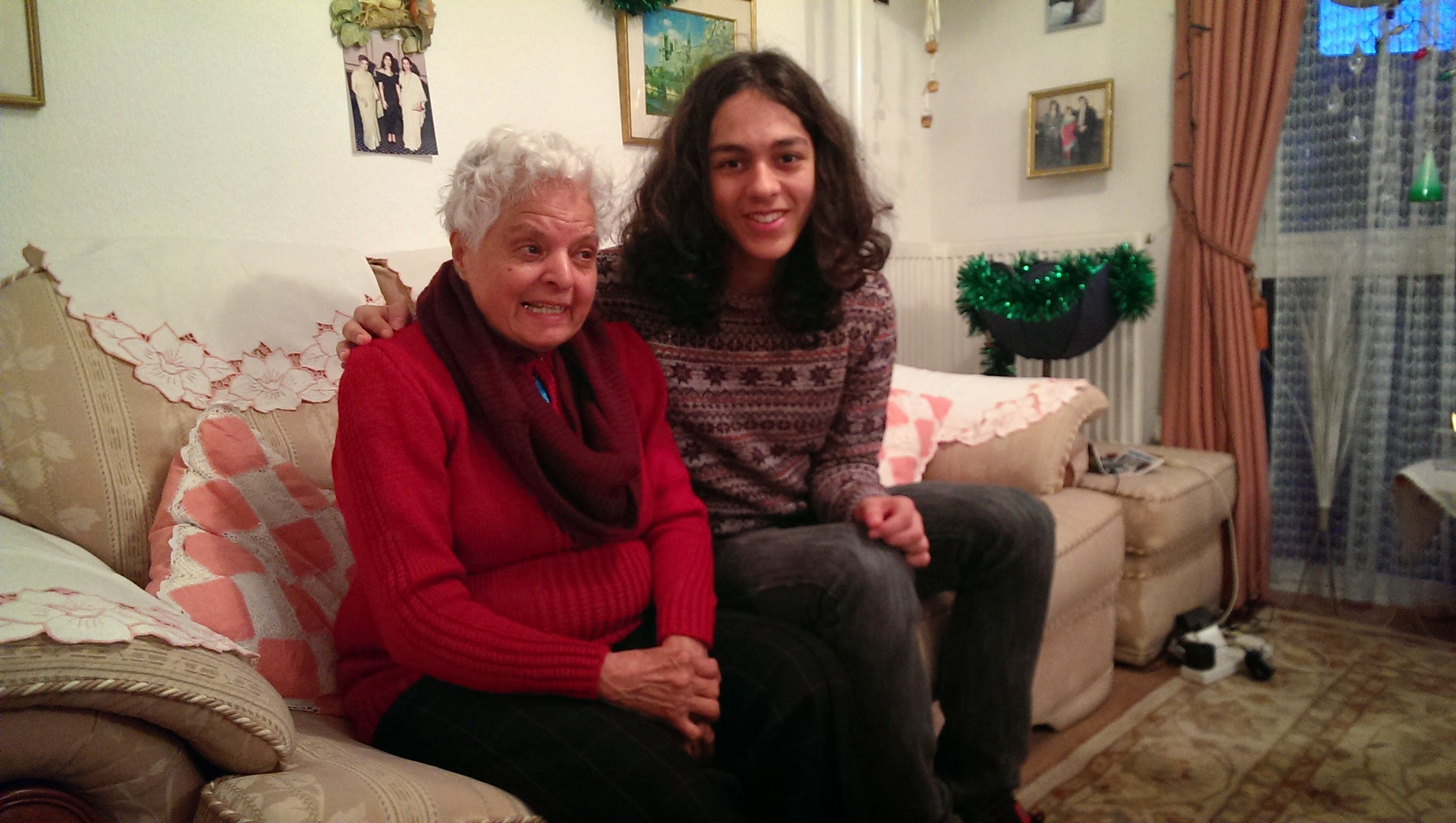 Surjit with her grandchild on the sofa, Christmas decorations visible