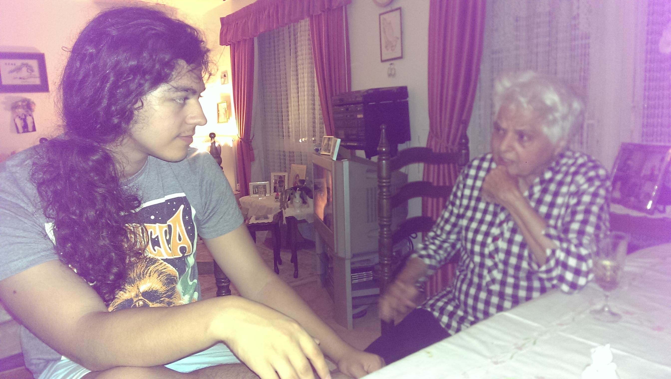 Surjit deep in conversation with her grandson at the table