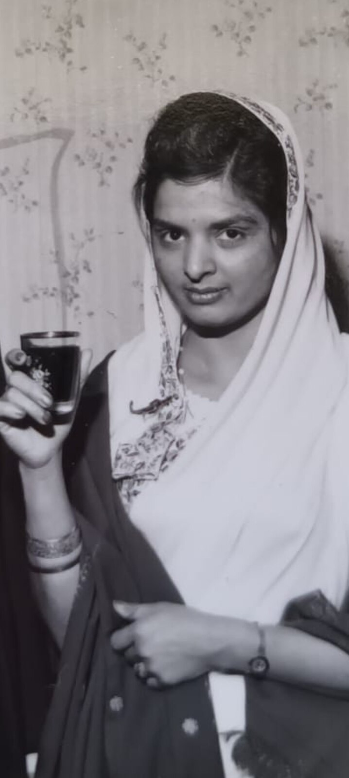 A young Surjit holding a drink at a gathering — a striking black-and-white photograph