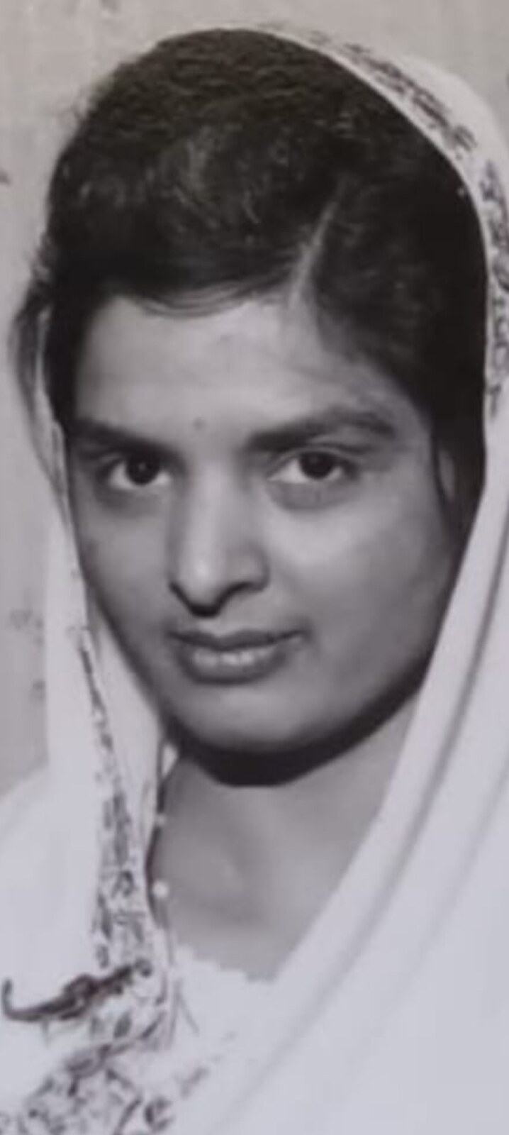A beautiful young portrait of Surjit wearing a delicate headscarf — a treasured black-and-white photograph