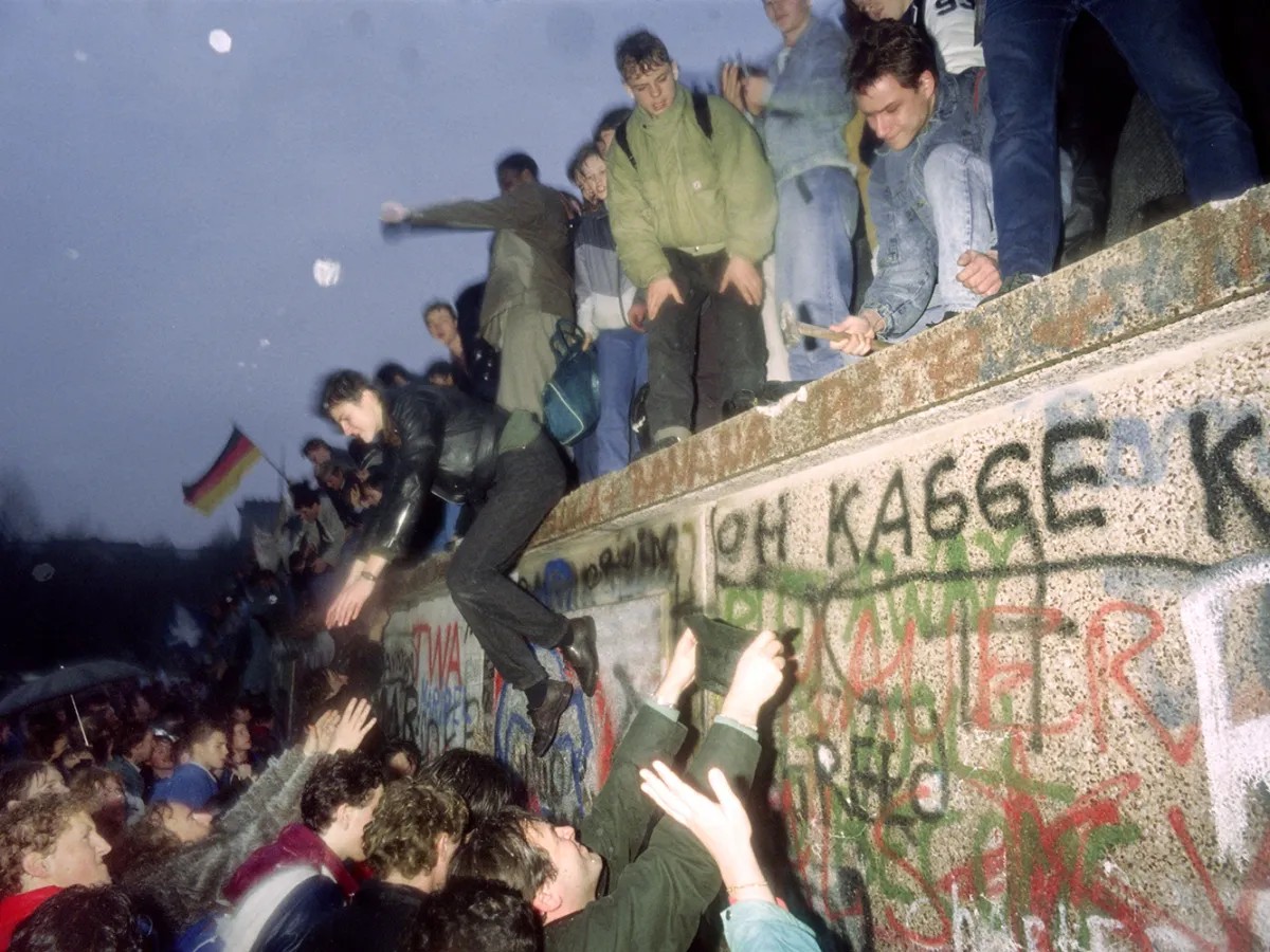 Crowds celebrating on the Berlin Wall in November 1989