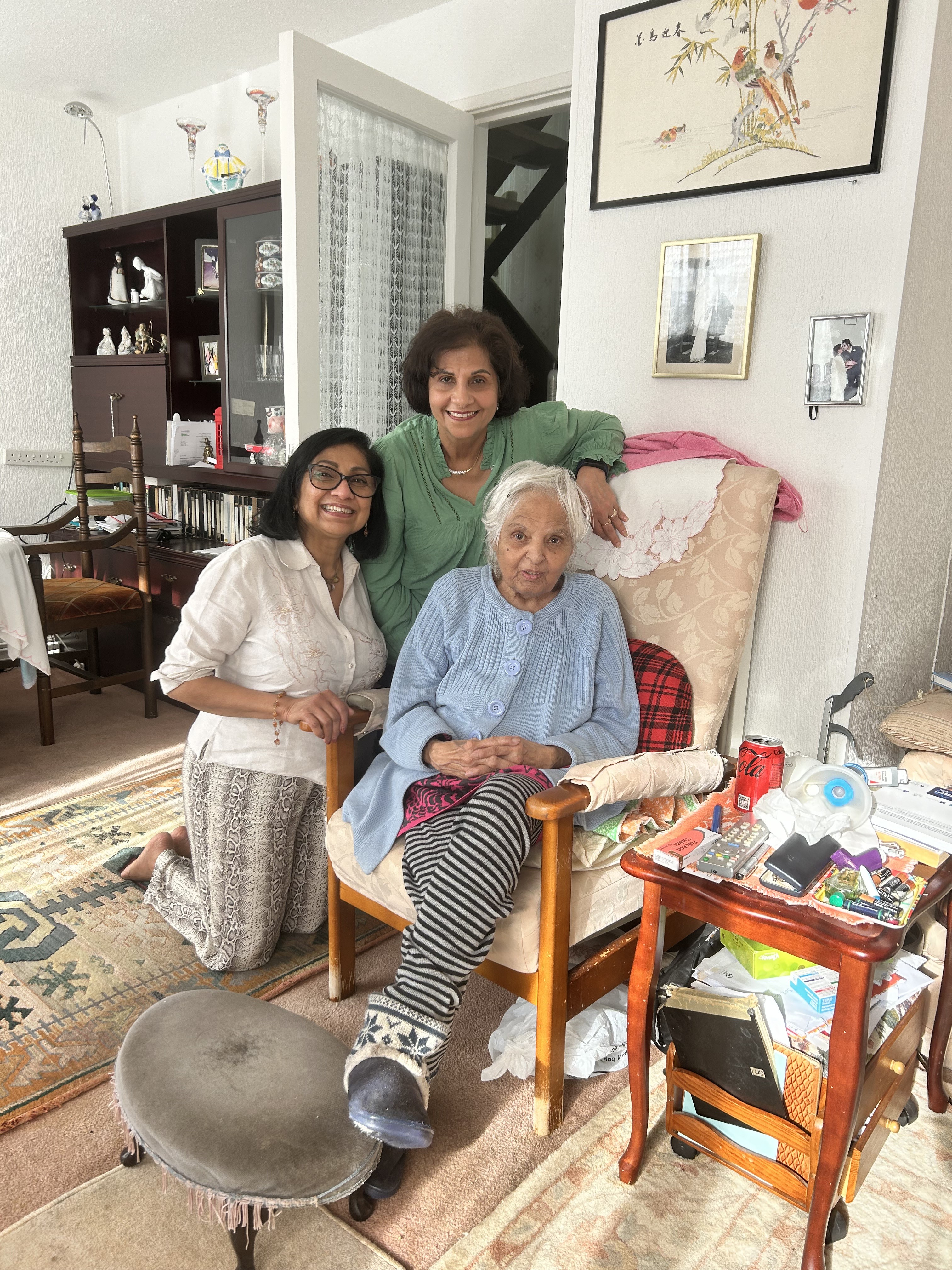 Surjit at home with a loved one kneeling beside her