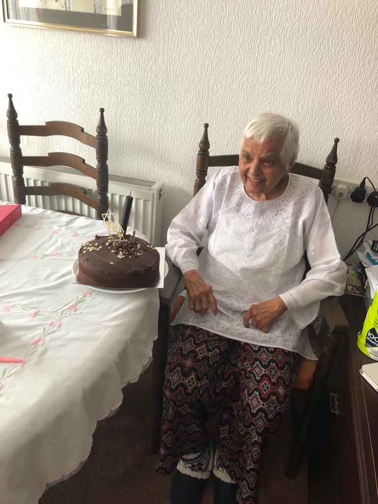 Surjit celebrating a birthday with a candle-lit cake at home