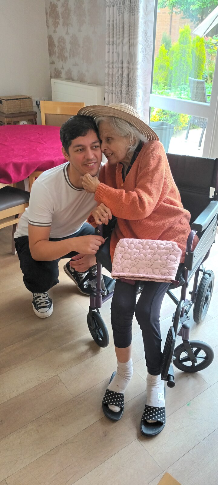 Surjit in an orange cardigan with her grandson, heads together smiling