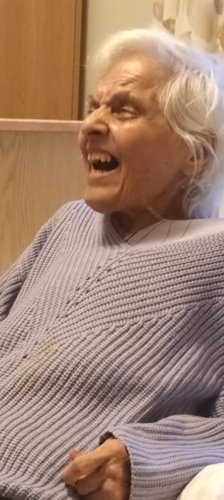 Surjit laughing wholeheartedly in a soft lilac jumper