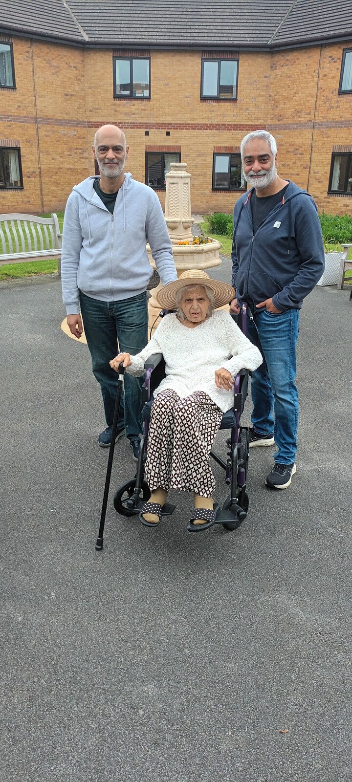Surjit out and about in her straw hat with both her sons by her side