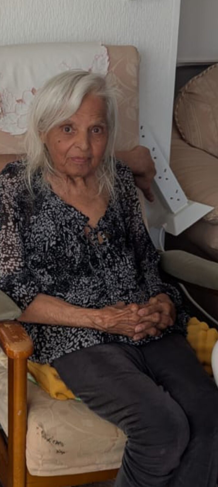 Surjit sitting peacefully in her favourite chair in a floral blouse