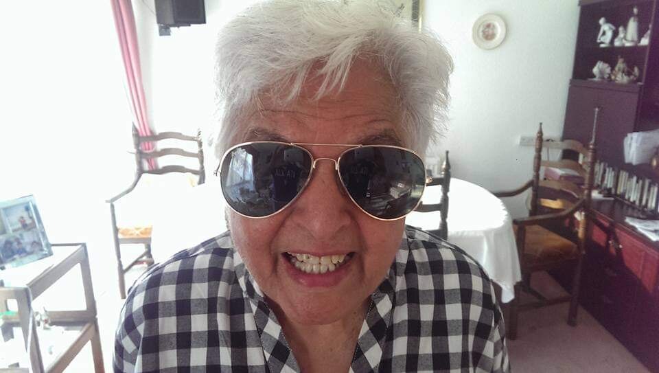 Surjit grinning with aviator sunglasses in a gingham shirt — forever young